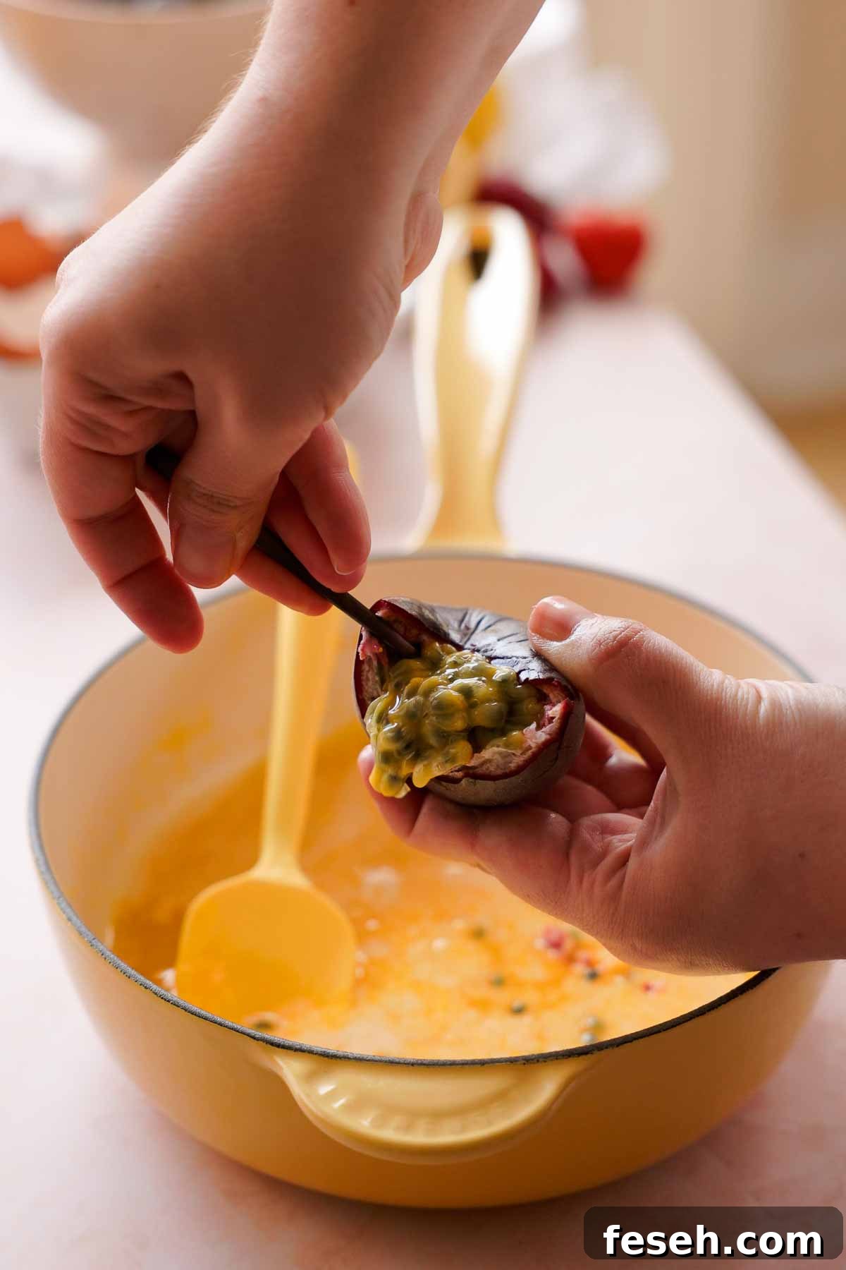 scooping passion fruit seeds into saucepan with curd