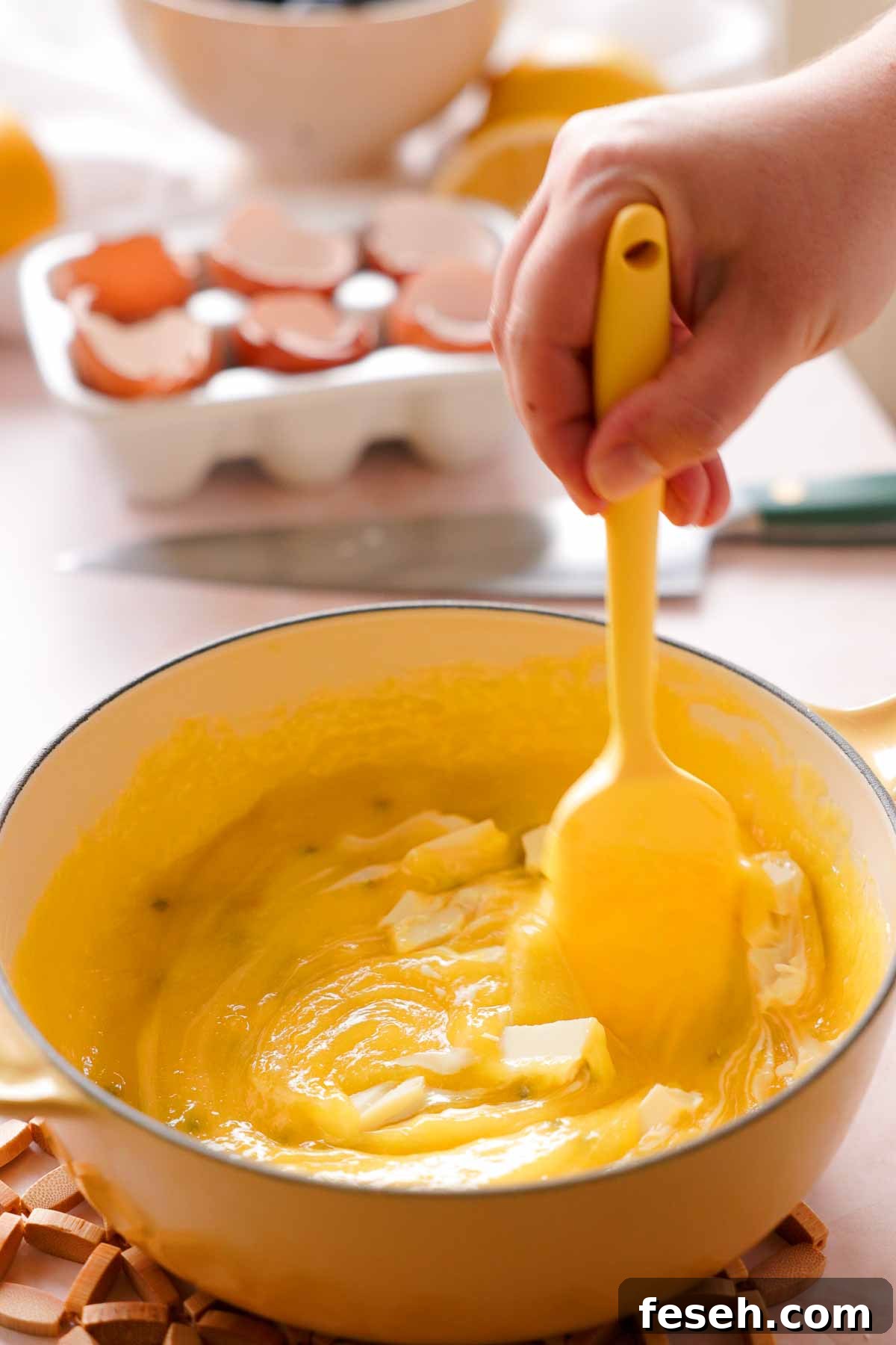stirring white chocolate into cooked lemon passion fruit curd