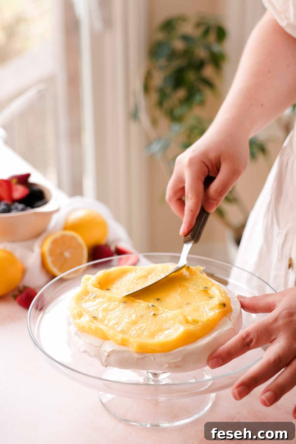 smoothing passion fruit lemon curd on pavlova layer