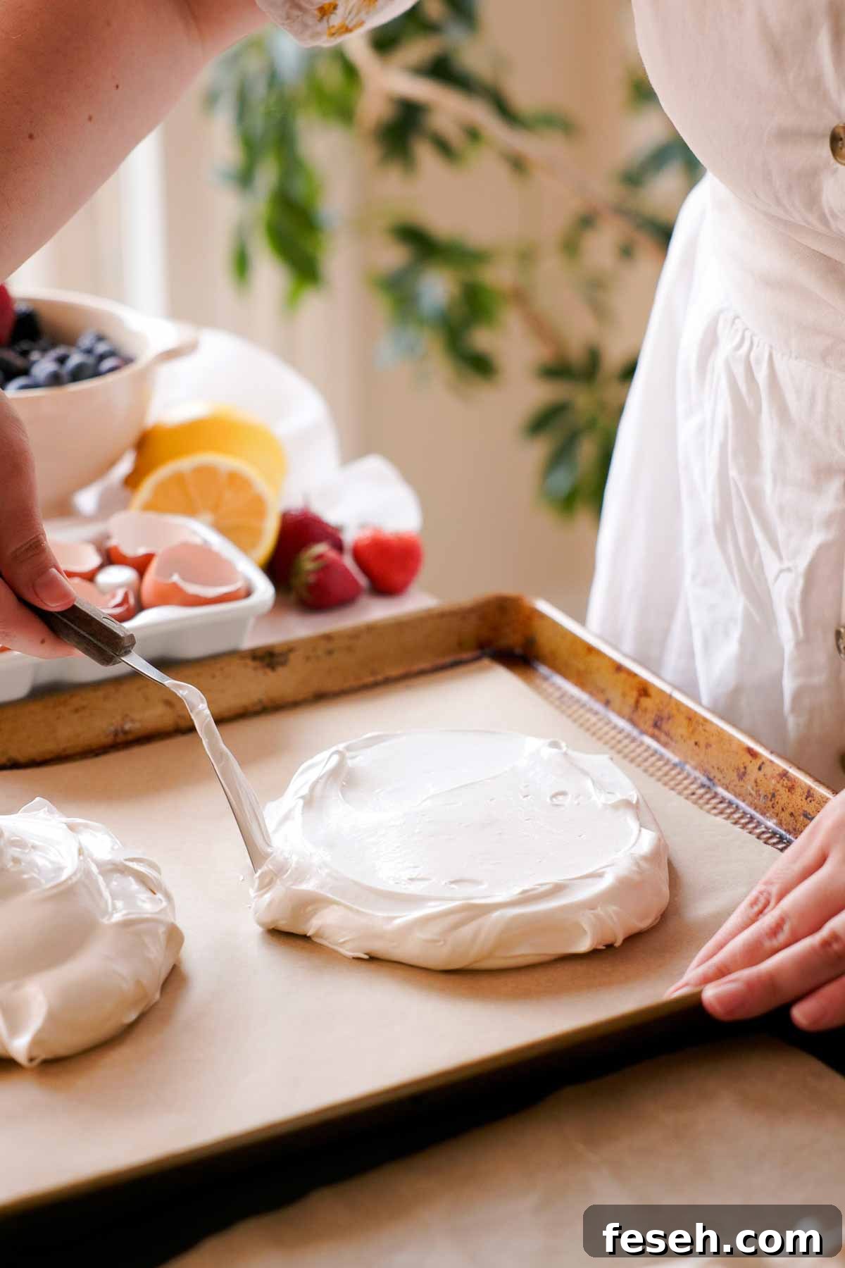 spreading out meringue into flat disks on parchment lined baking sheet