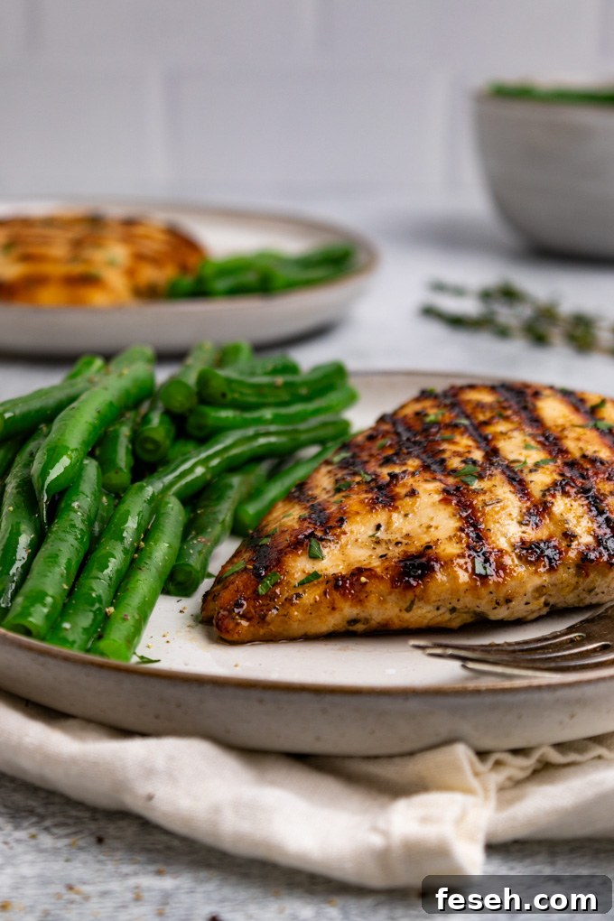 Angled, close up shot of Italian marinated chicken with green beans on the plate.