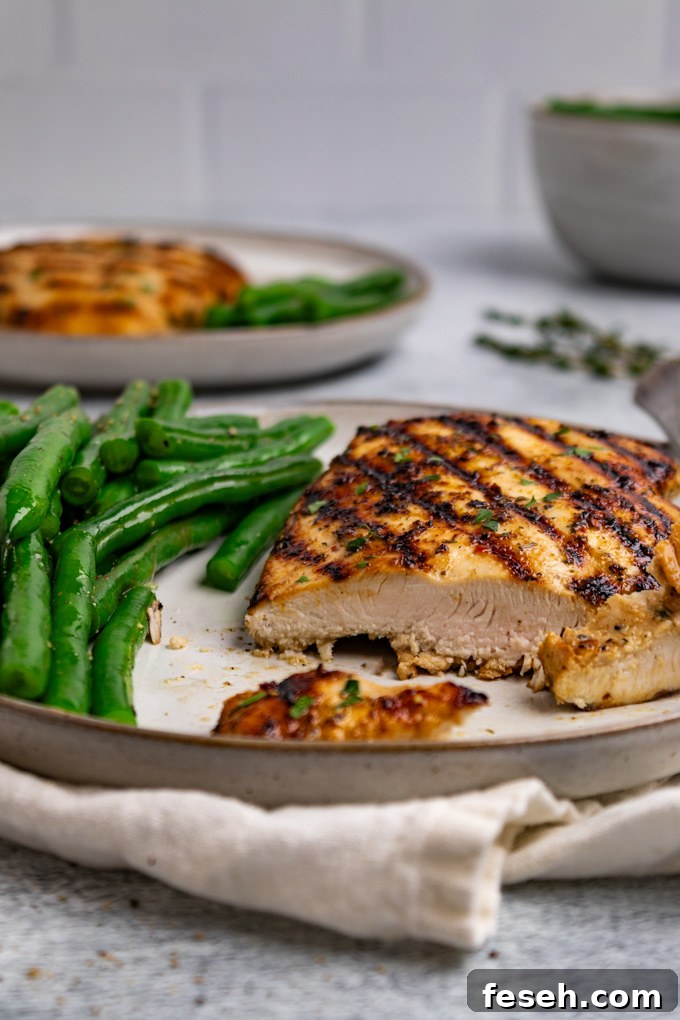 Angled close up shot of Italian marinated chicken with a slice cut from the chicken.