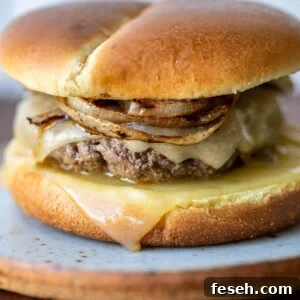 A grilled onion cheddar burger on a plate.