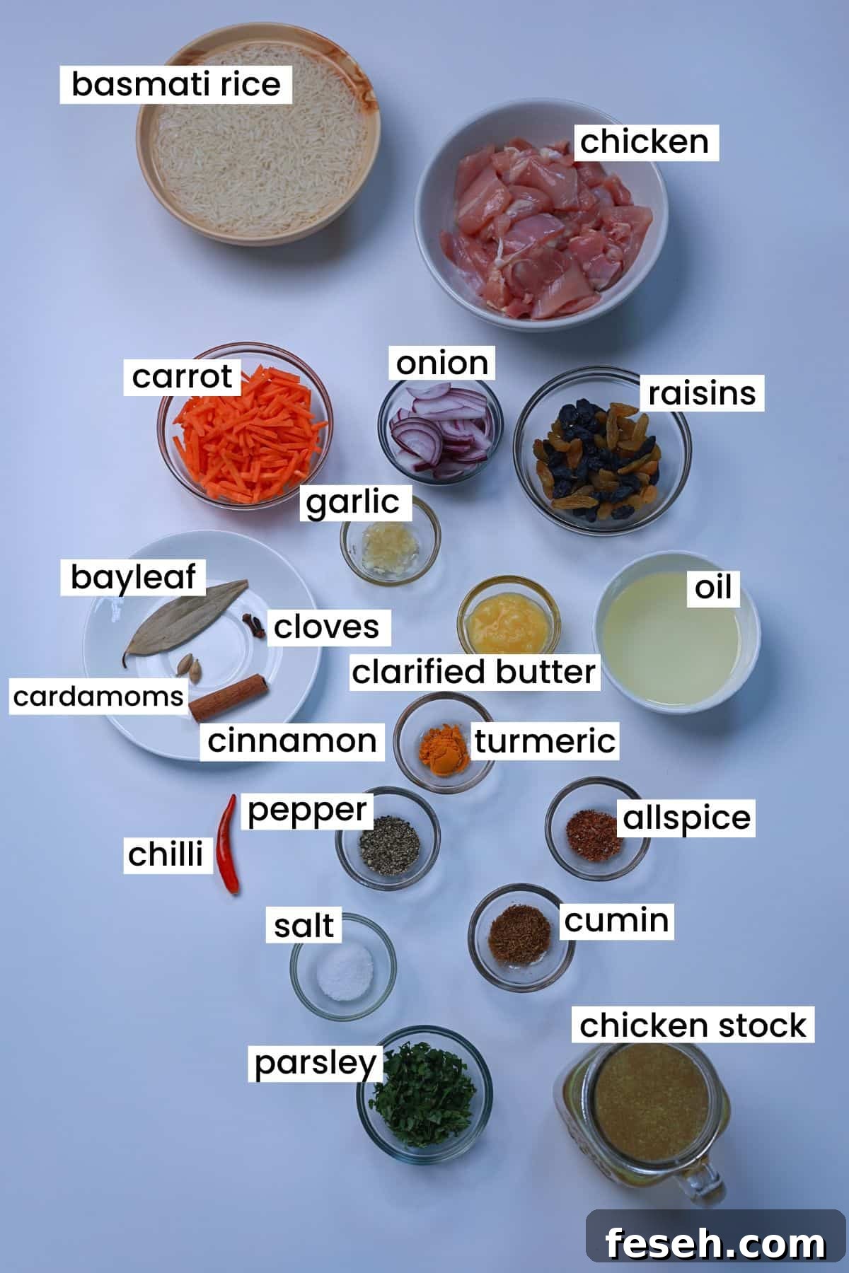 Ingredients for easy one-pot chicken pilaf including basmati rice, chicken thighs, carrots, raisins, onions, garlic, whole and ground spices, and fresh parsley.