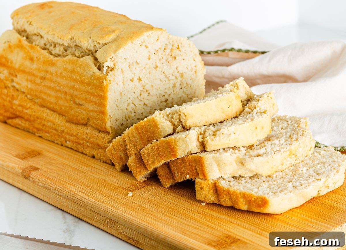 A loaf of gluten free bread sliced on a cutting board. 