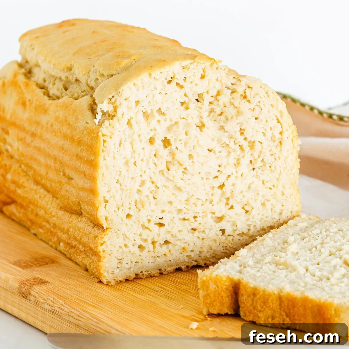A loaf of gluten free dairy free bread with one slice next to it.