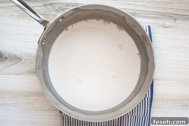 Creamy sauce cooking in a saucepan.