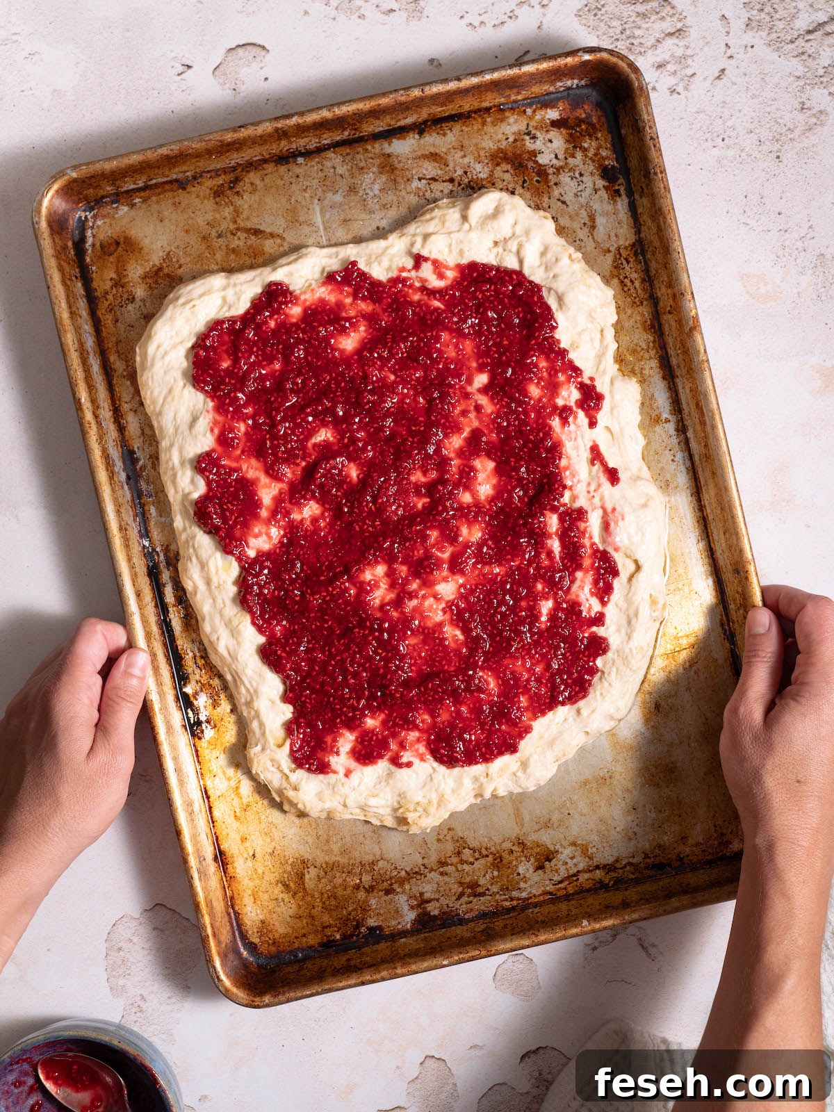 Raspberry jam spread on focaccia dough
