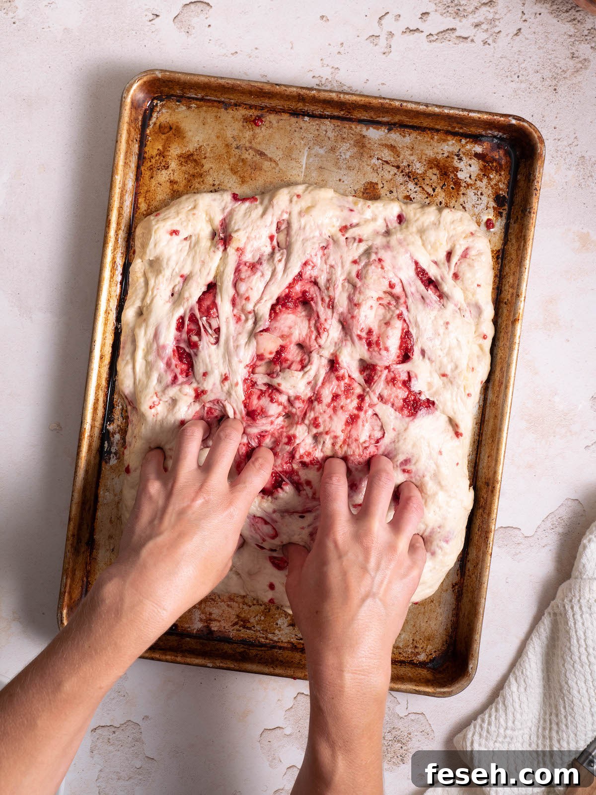 Dimpling focaccia dough before baking