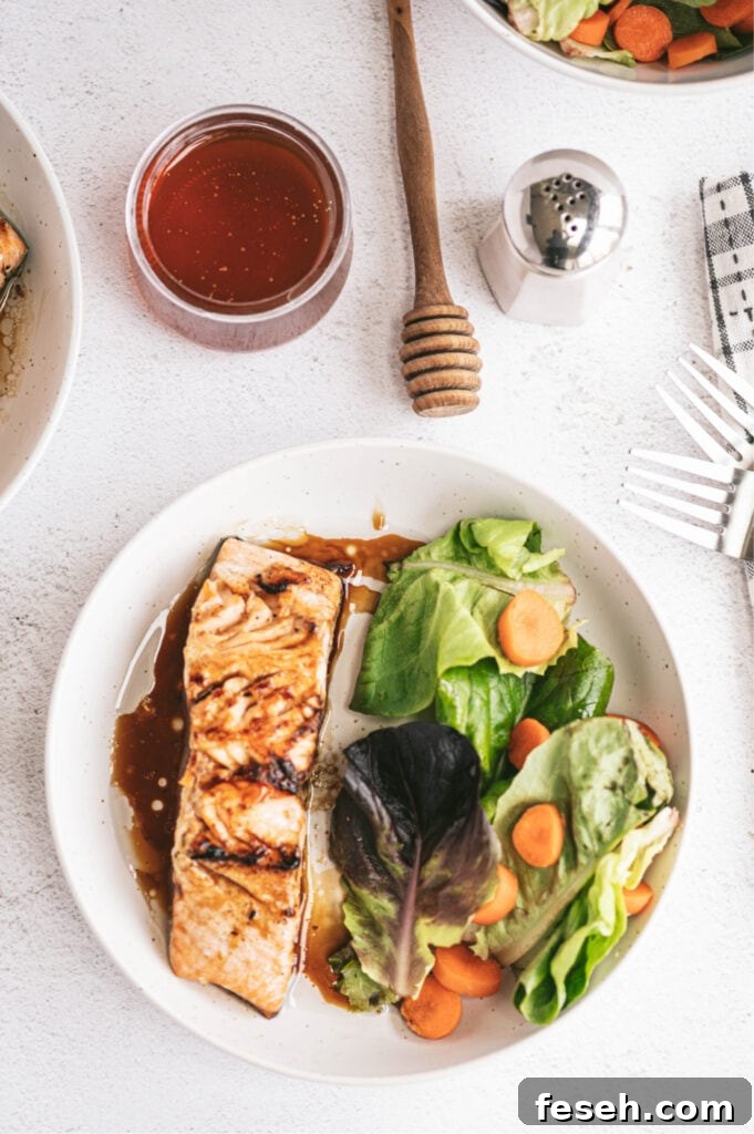 honey glazed salmon oven baked on a white plate with side salad