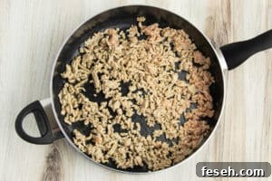 Picture of skillet with ground chicken cooking.