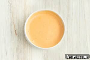 Picture of a small white bowl with sriracha mayonnaise sauce.