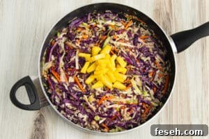 Picture of skillet with egg roll in a bowl with pineapple added.
