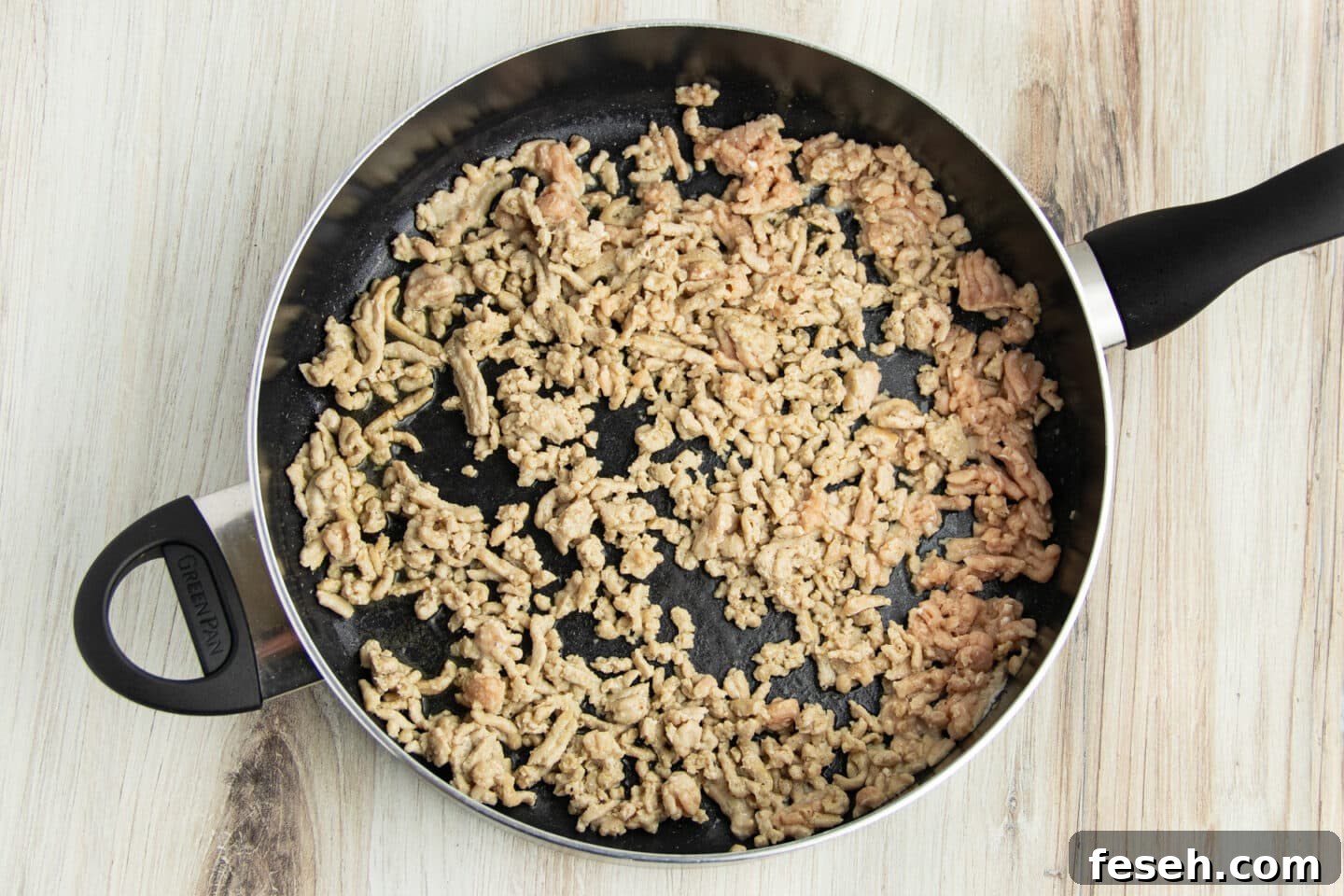 Picture of skillet with ground chicken cooking.