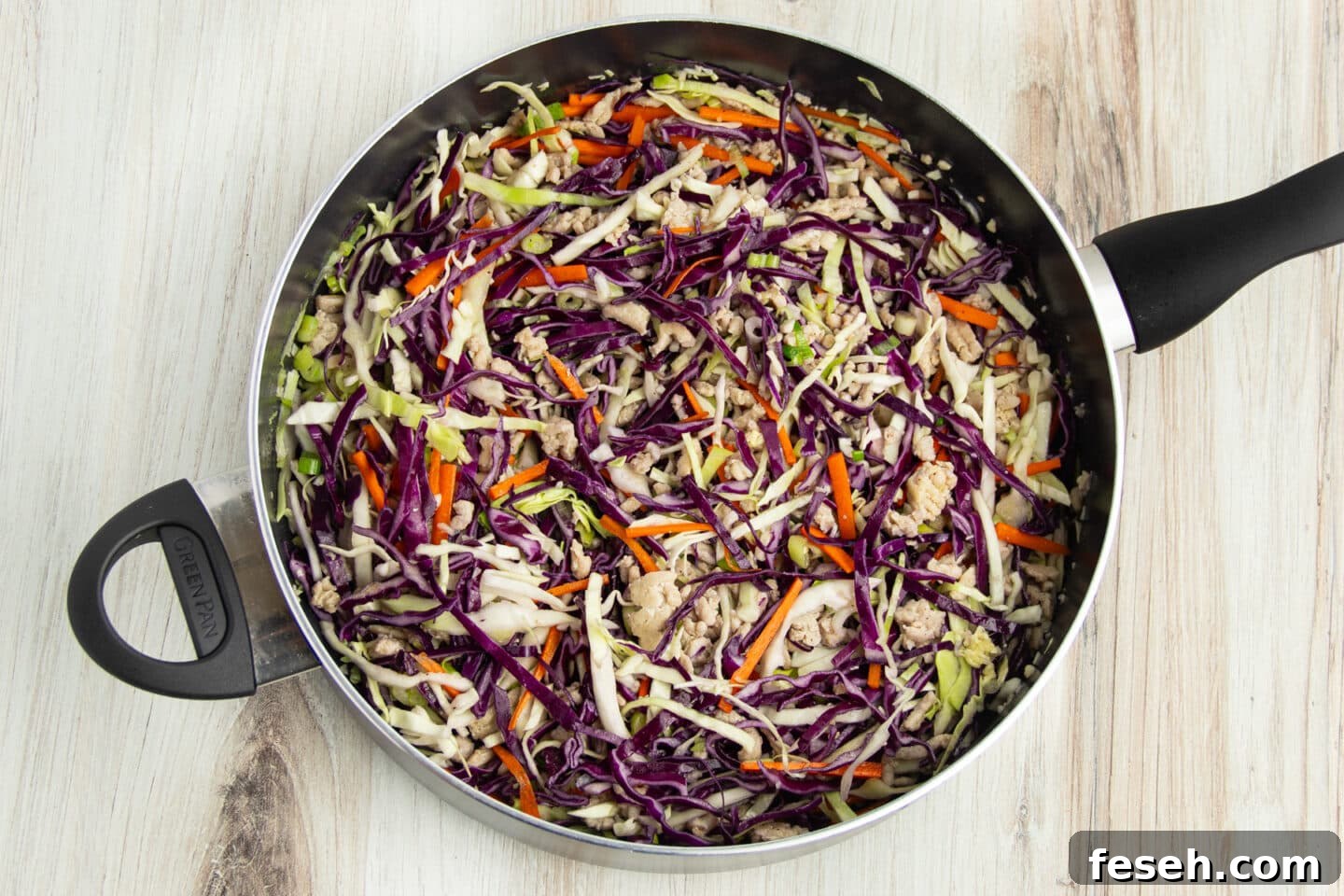 Picture of skillet with egg roll in a bowl cooking.