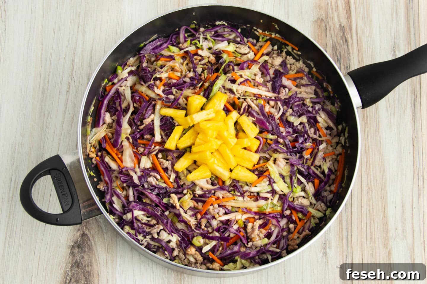 Picture of skillet with egg roll in a bowl with pineapple added.