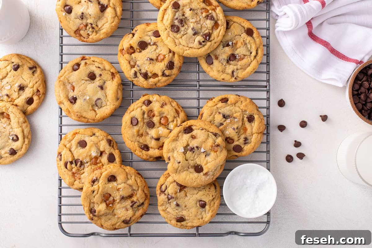 Salted caramel chocolate chip cookies arranged on a wire rack.