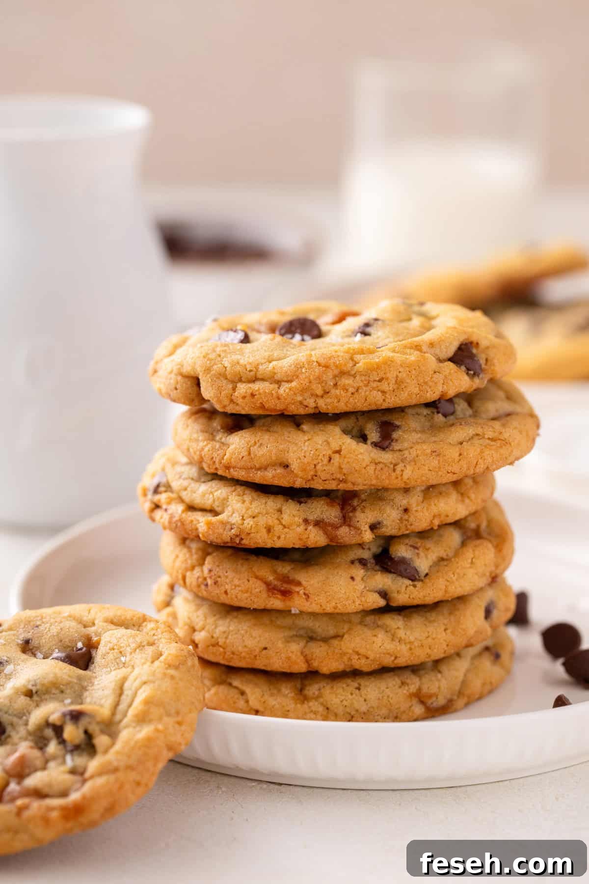 Stack of salted caramel chocolate chip cookies on a white plate.