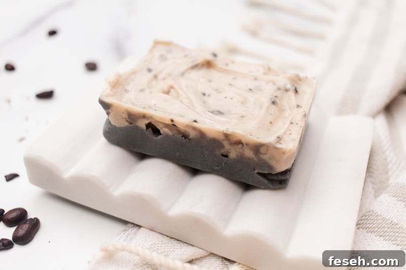 Layered vanilla coffee exfoliating soap bar on a soap tray.