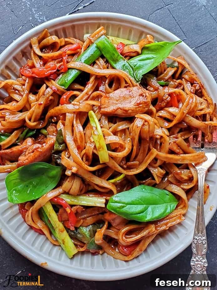 instant pot drunken noodles in a beige plate with a silver fork