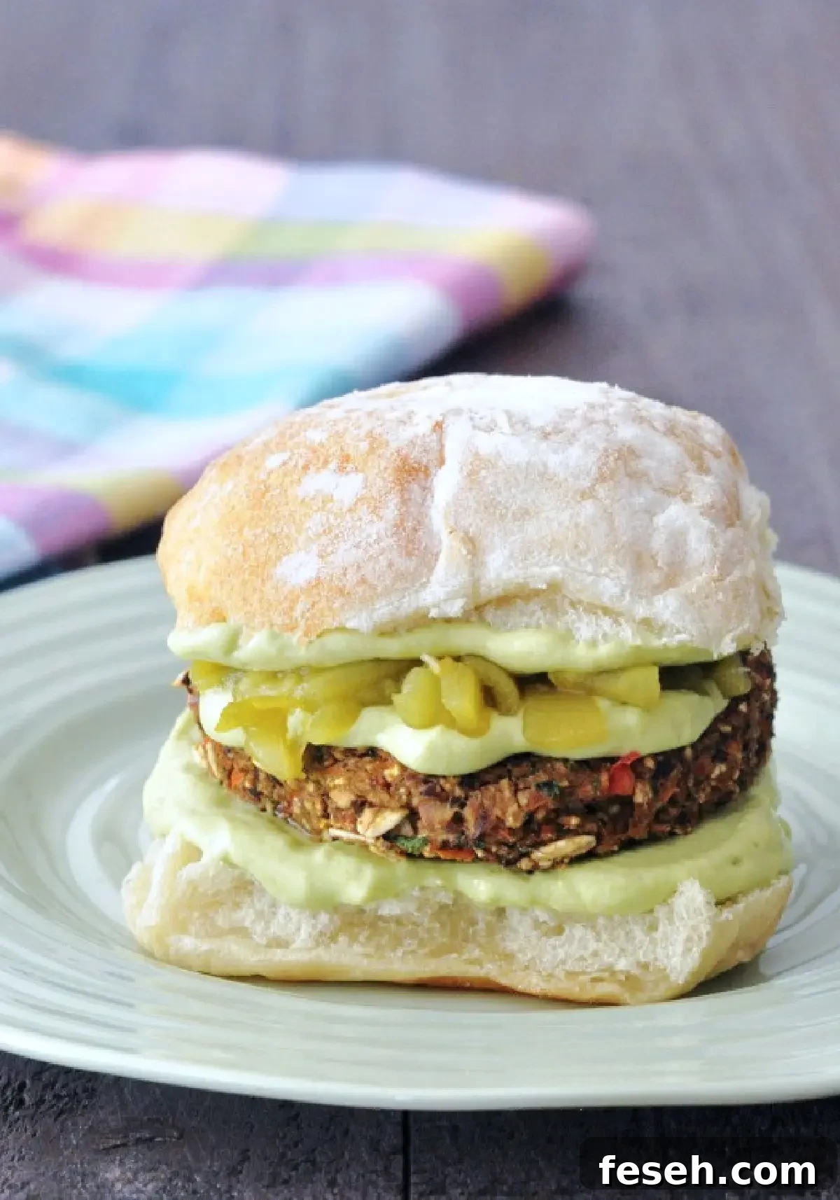 a veggie burger topped with avocado sauce and Hatch chiles
