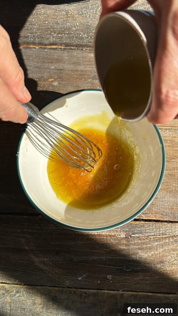 a photo of a hand whisking the salad dressing in a small bowl