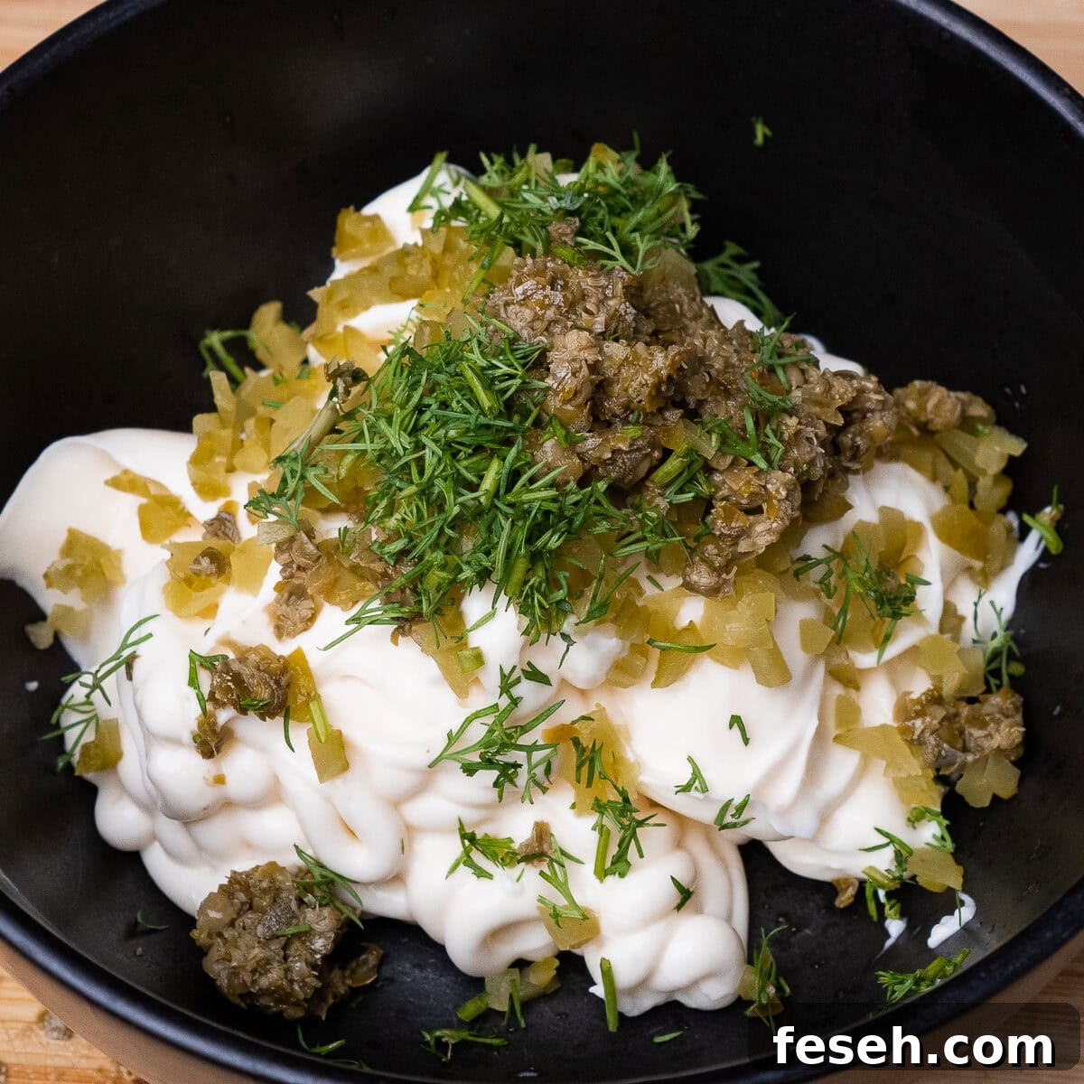Mayonnaise, chopped capers, Gerkin and dill in a bowl