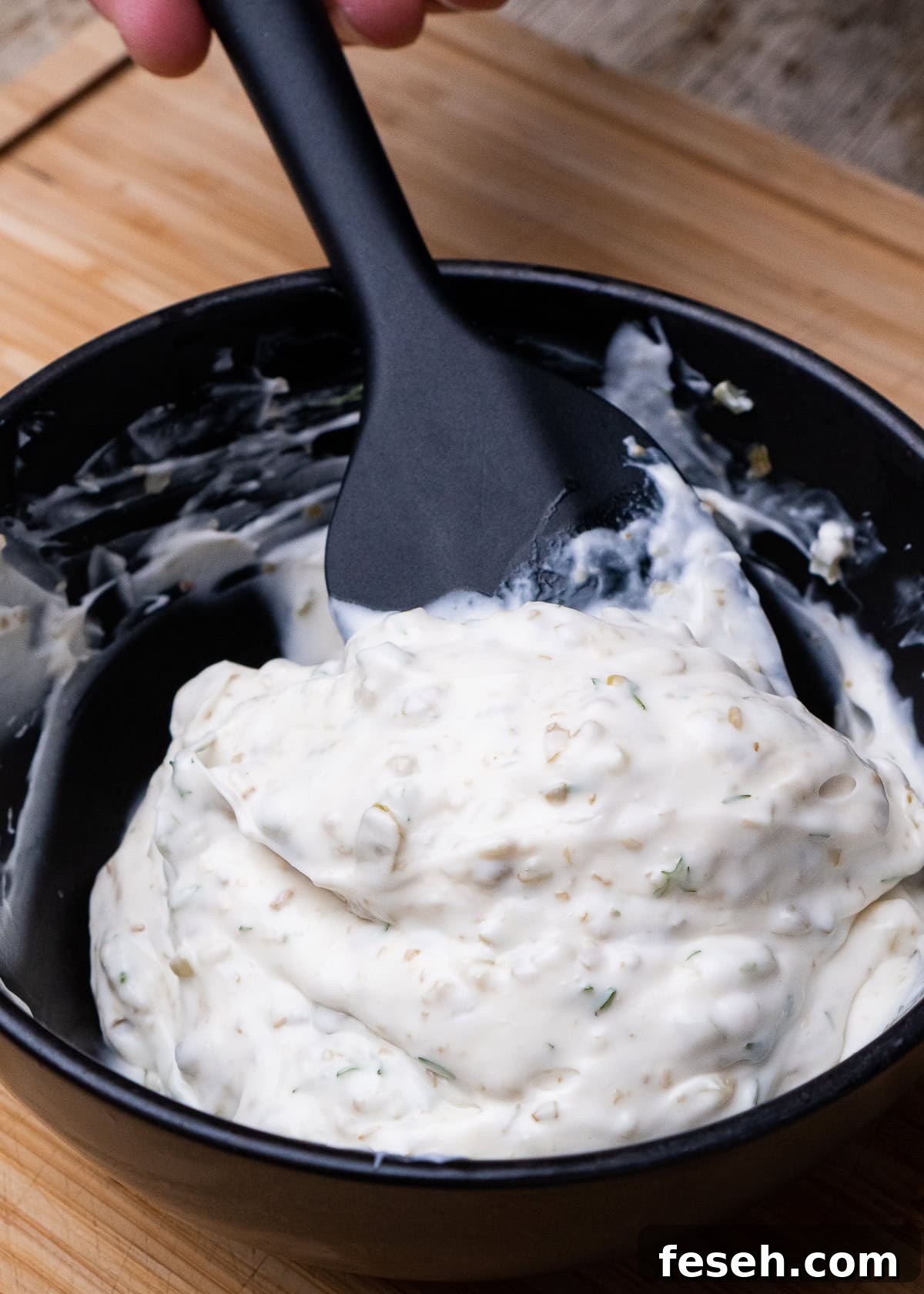 Stirring our tartar sauce together with a spoon