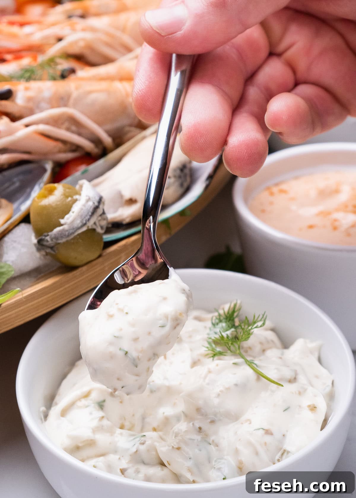 Tartare Sauce being picked up with a teaspoon from a bowl of tartar sauce