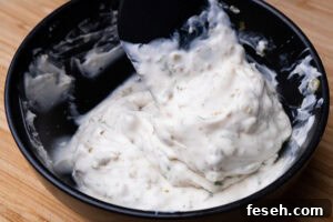 Stirring our homemade tartare sauce together with a spoon