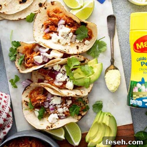 Tacos of chicken tinga with toppings on a white board