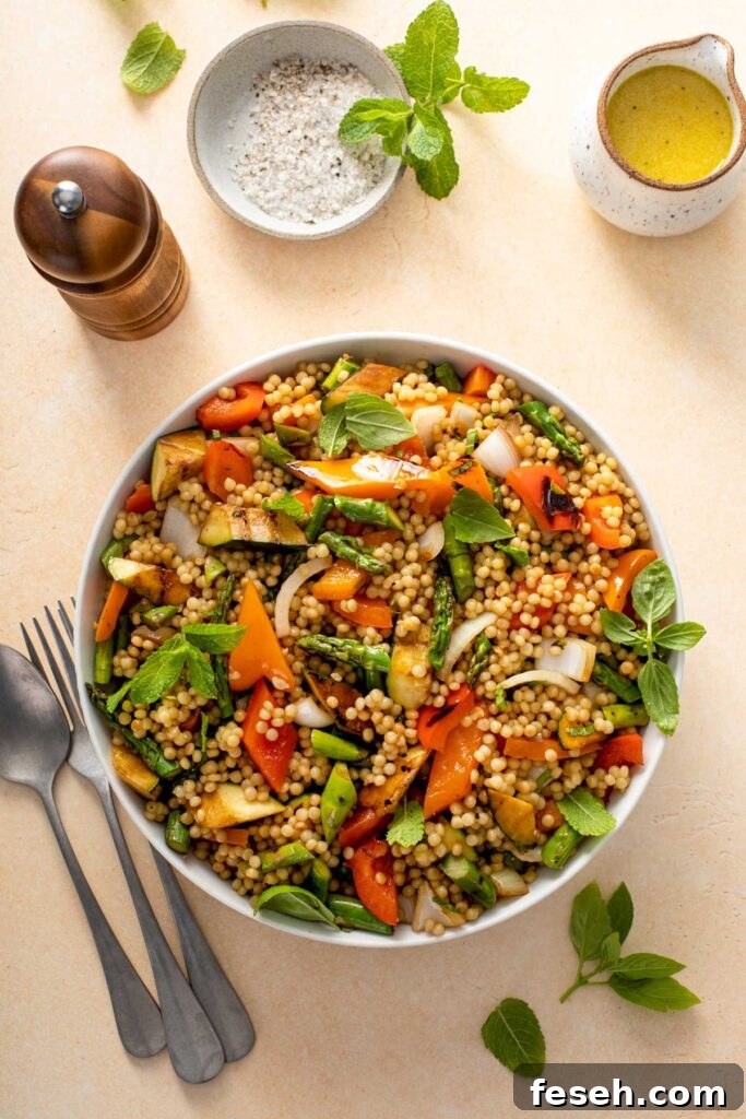 Top view of a bowl filled with cooked pearl couscous and grilled vegetables