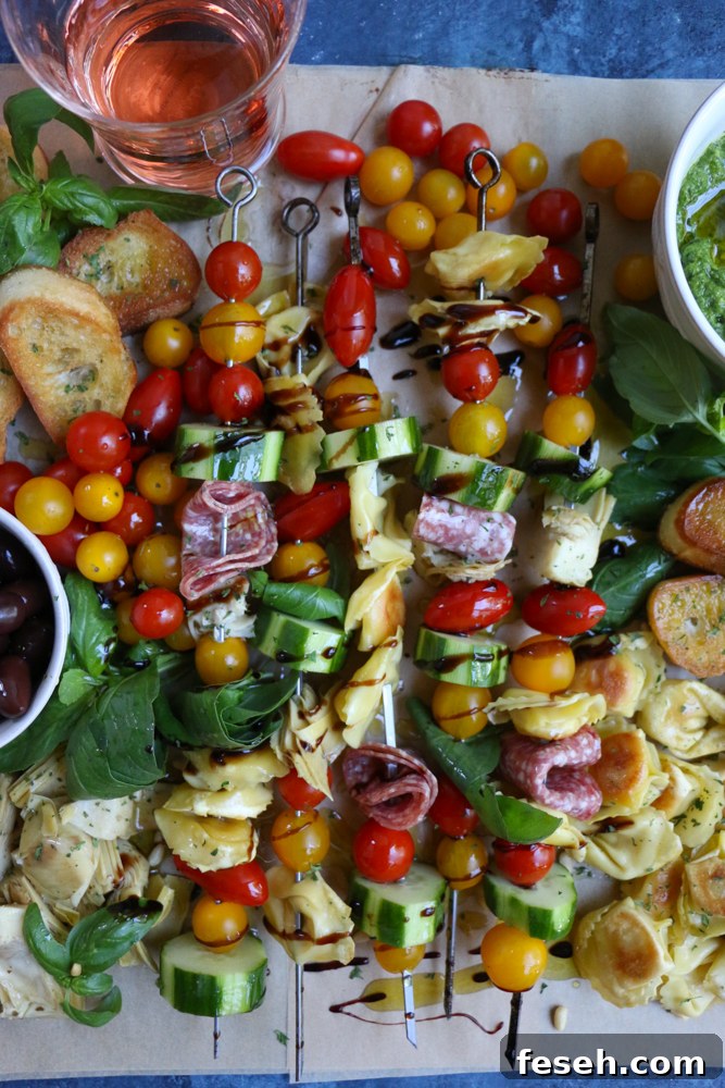Summer Tortellini Pasta Salad on skewers surrounded by slices of bread and a glass of wine.
