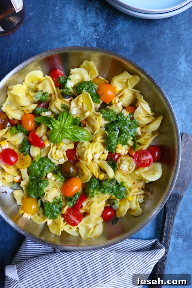 A skillet of Summer Tortellini Pasta Salad with a napkin.