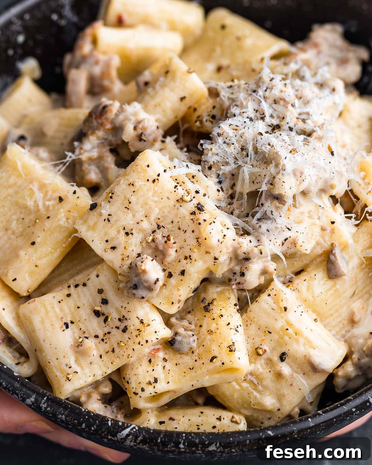 Pasta alla Norcina held in black bowl.