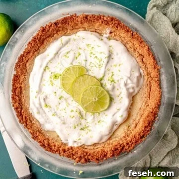 A key lime pie in a clear pie dish.