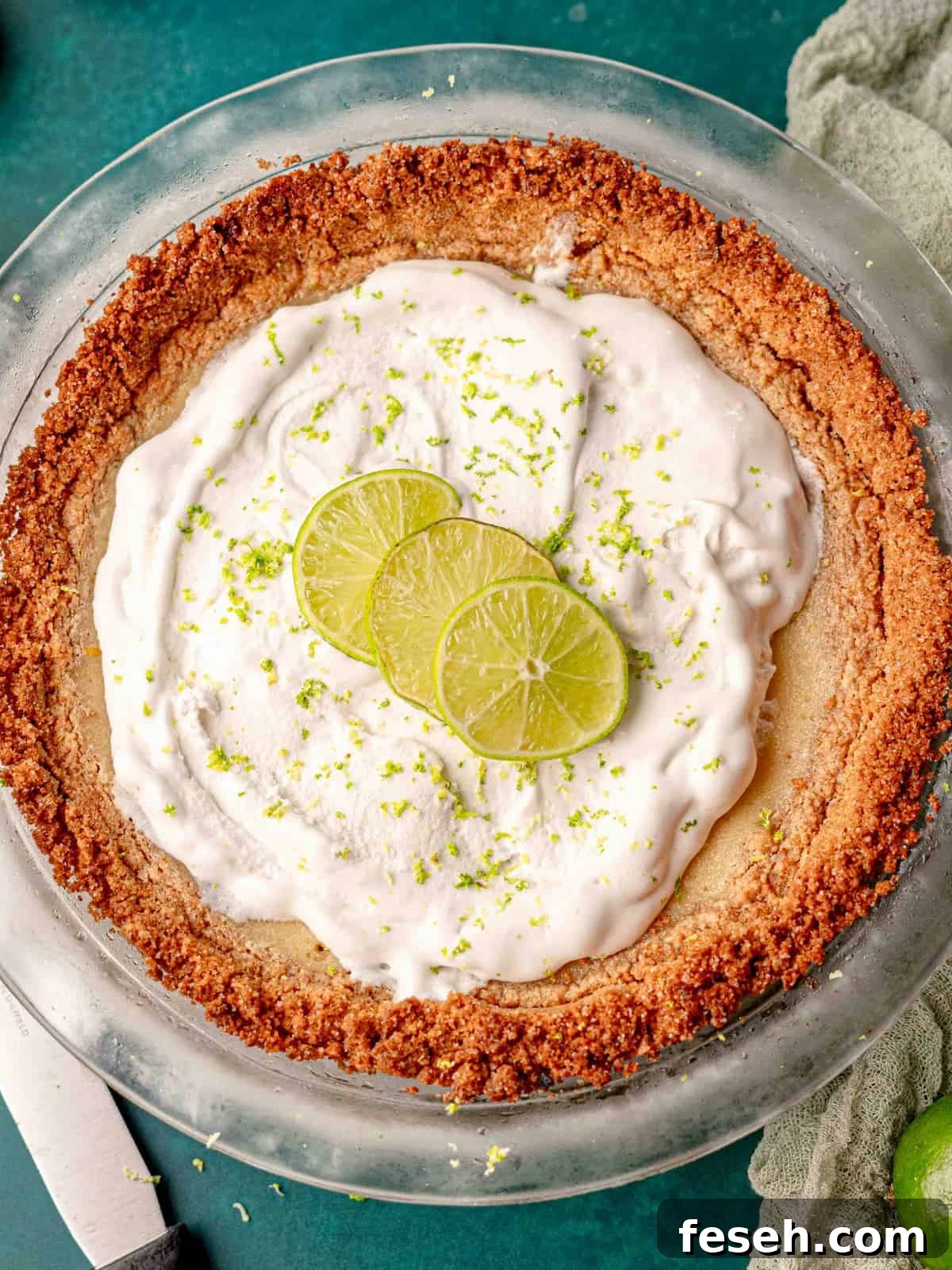 Key lime pie with whipped topping and lime slices on top.