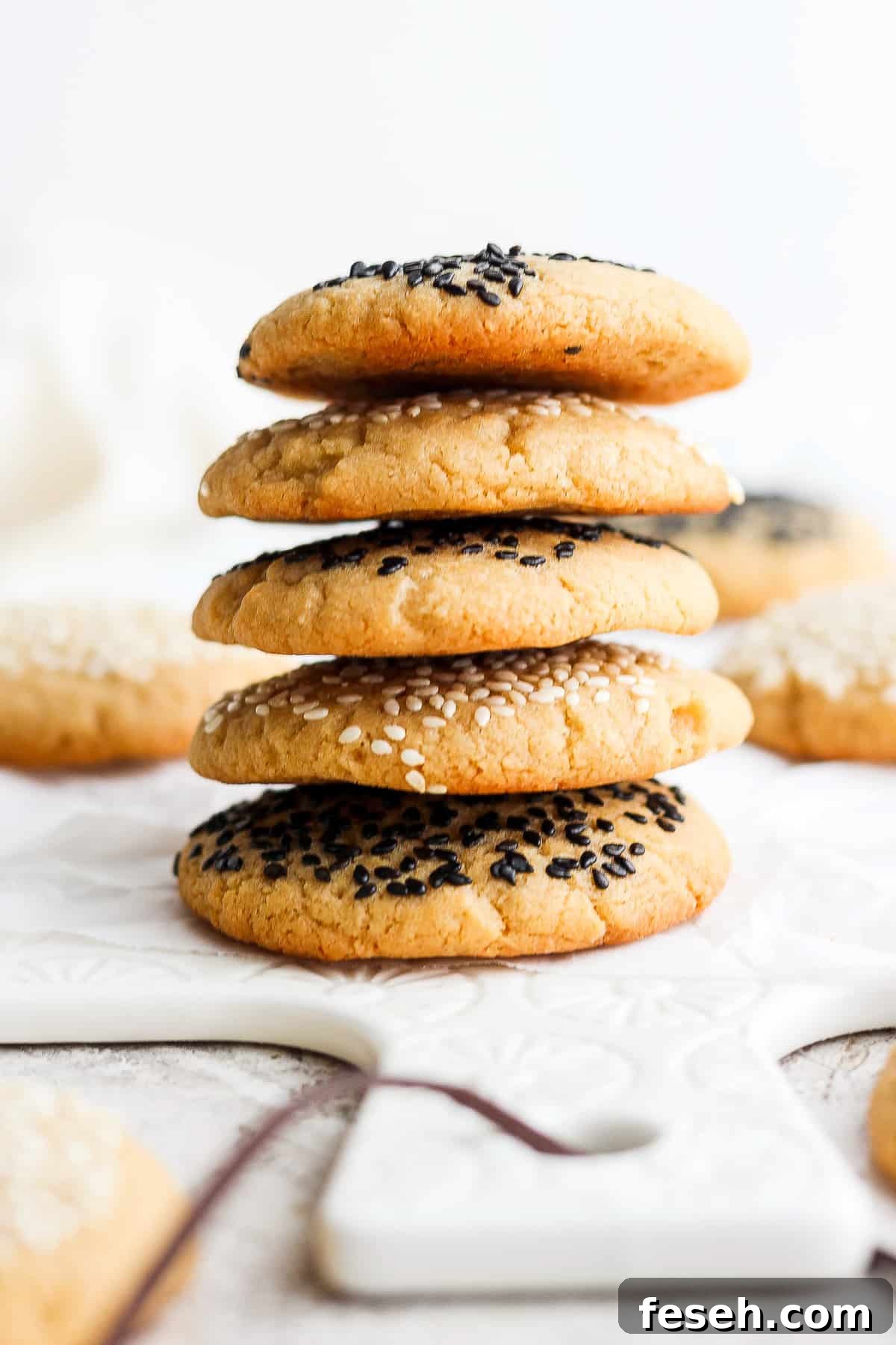 a stack of cookies with sesame seeds on top.