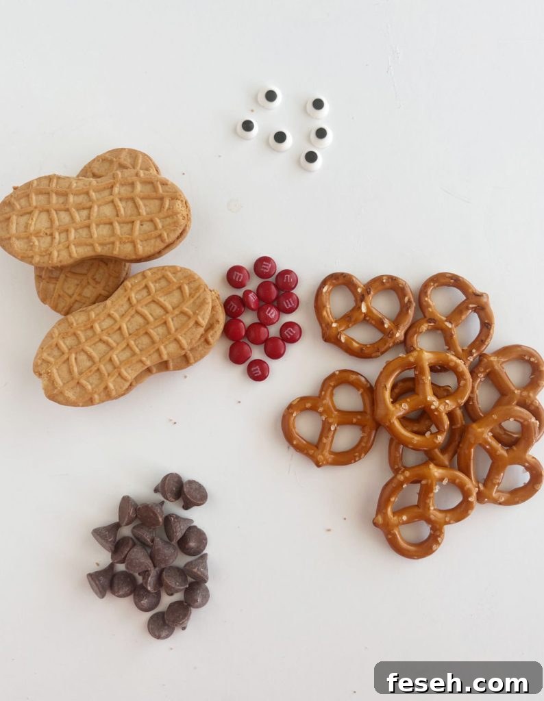 peanut butter cookies, chocolate, candy eyes, pretzels and red m and ms on the table
