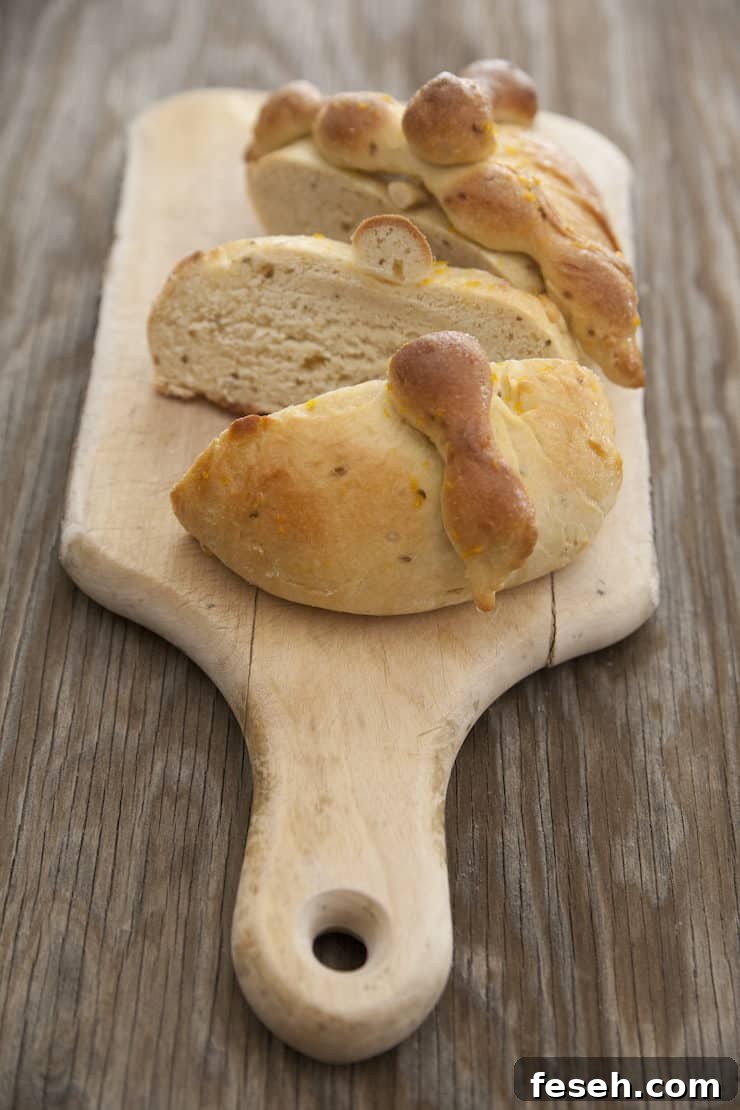 Slices of traditional Pan de Muerto bread with bone-shaped dough decorations, served on a rustic wooden board.