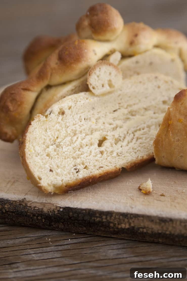 Slices of traditional Pan de Muerto bread with bone-shaped dough decorations, served on a rustic wooden board.