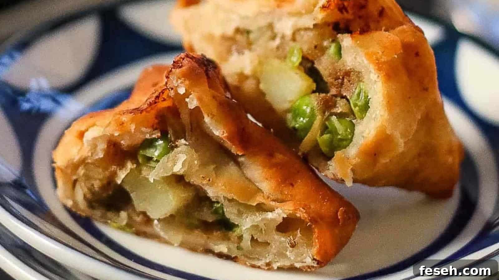 Low angle shot of a samosa cut in half so that you can see the potato filling inside.