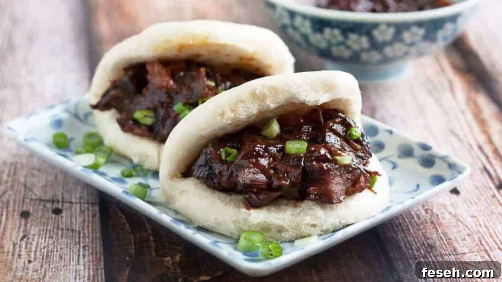 Low angle shot of two mantou buns filled with char siu filling.