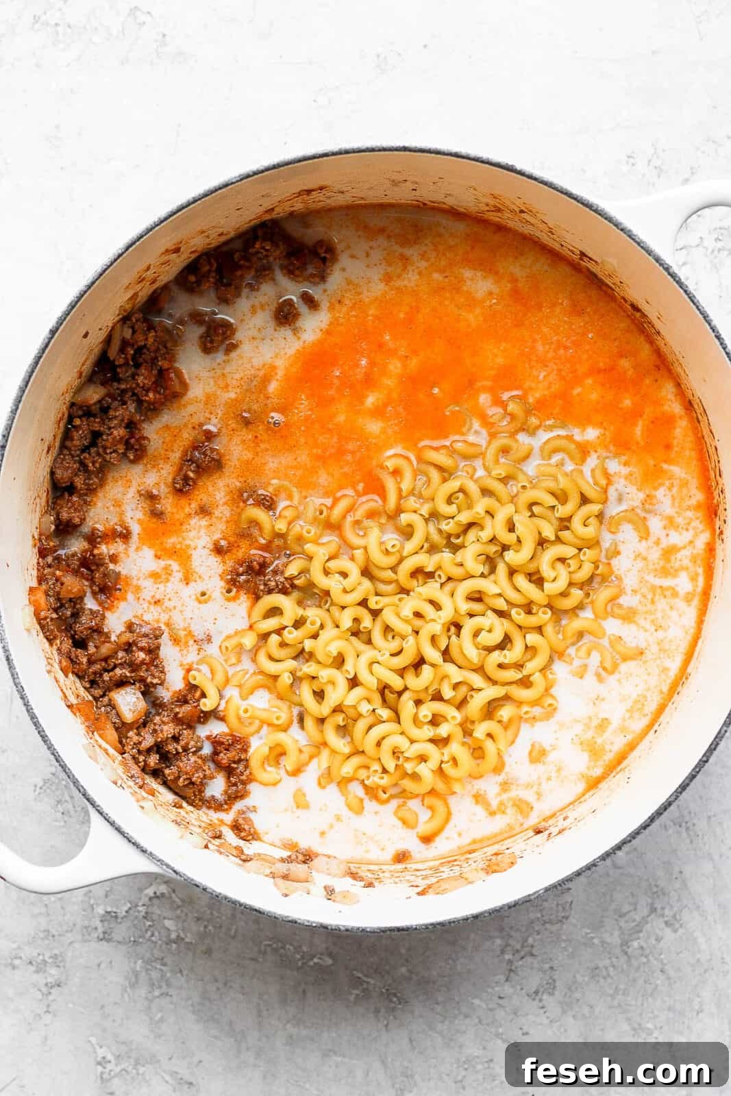 Macaroni noodles being added to the pot.