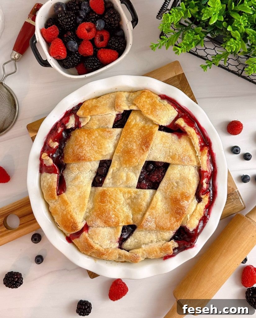 Triple Berry Deep Dish Galette in a white pie dish and a dish of fresh berries.