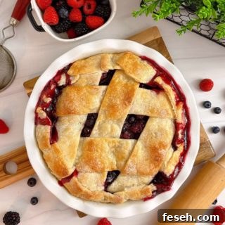 Triple Berry Deep Dish Galette in a white pie dish and a dish of fresh berries.