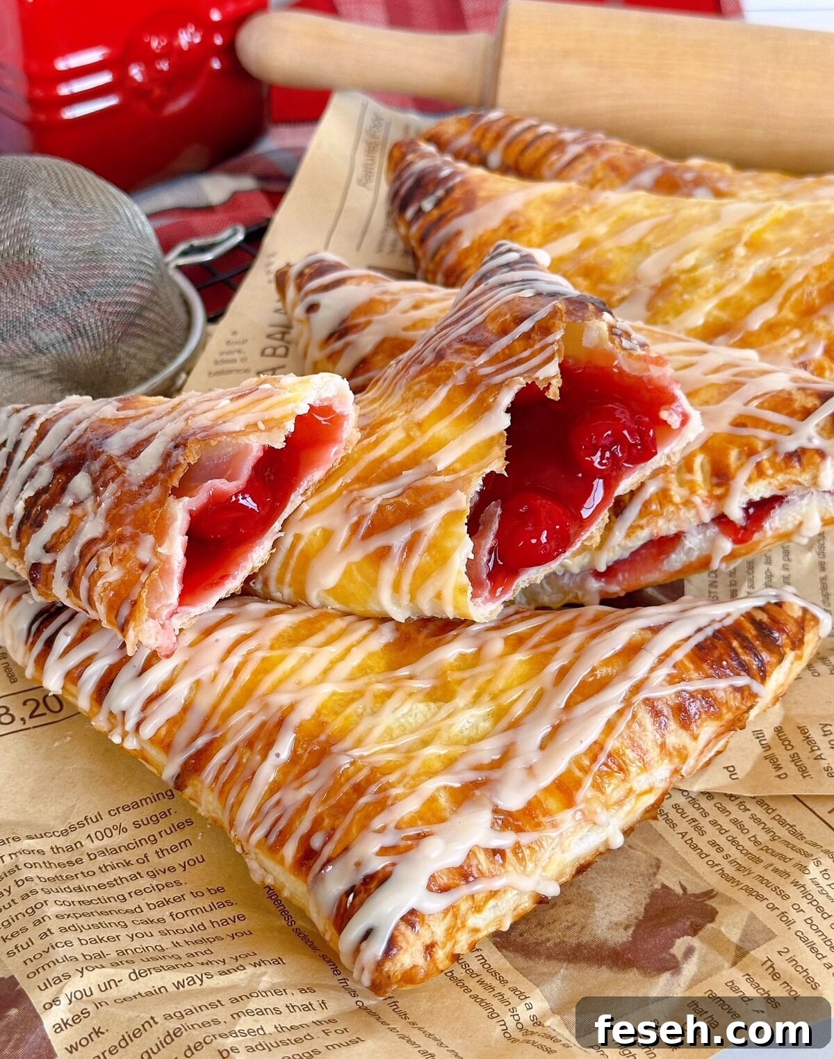 Cherry turnovers broken open and piled high on printed parchment paper.