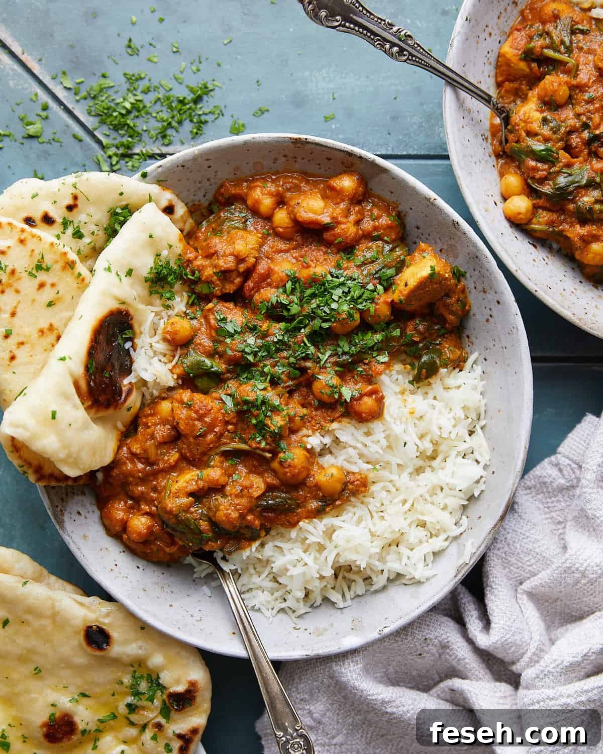 Overhead image of healthy chicken tikka masala in bowl with garnish.