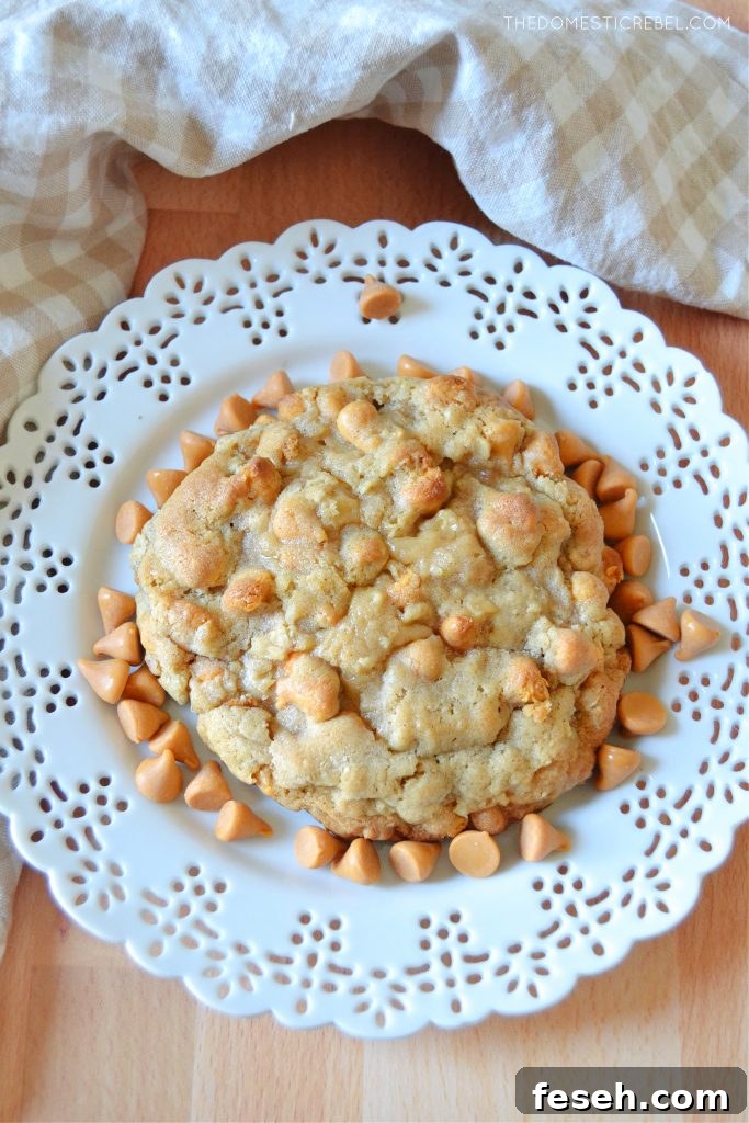 an oatmeal scotchie cookie on a white lace plate with butterscotch chips