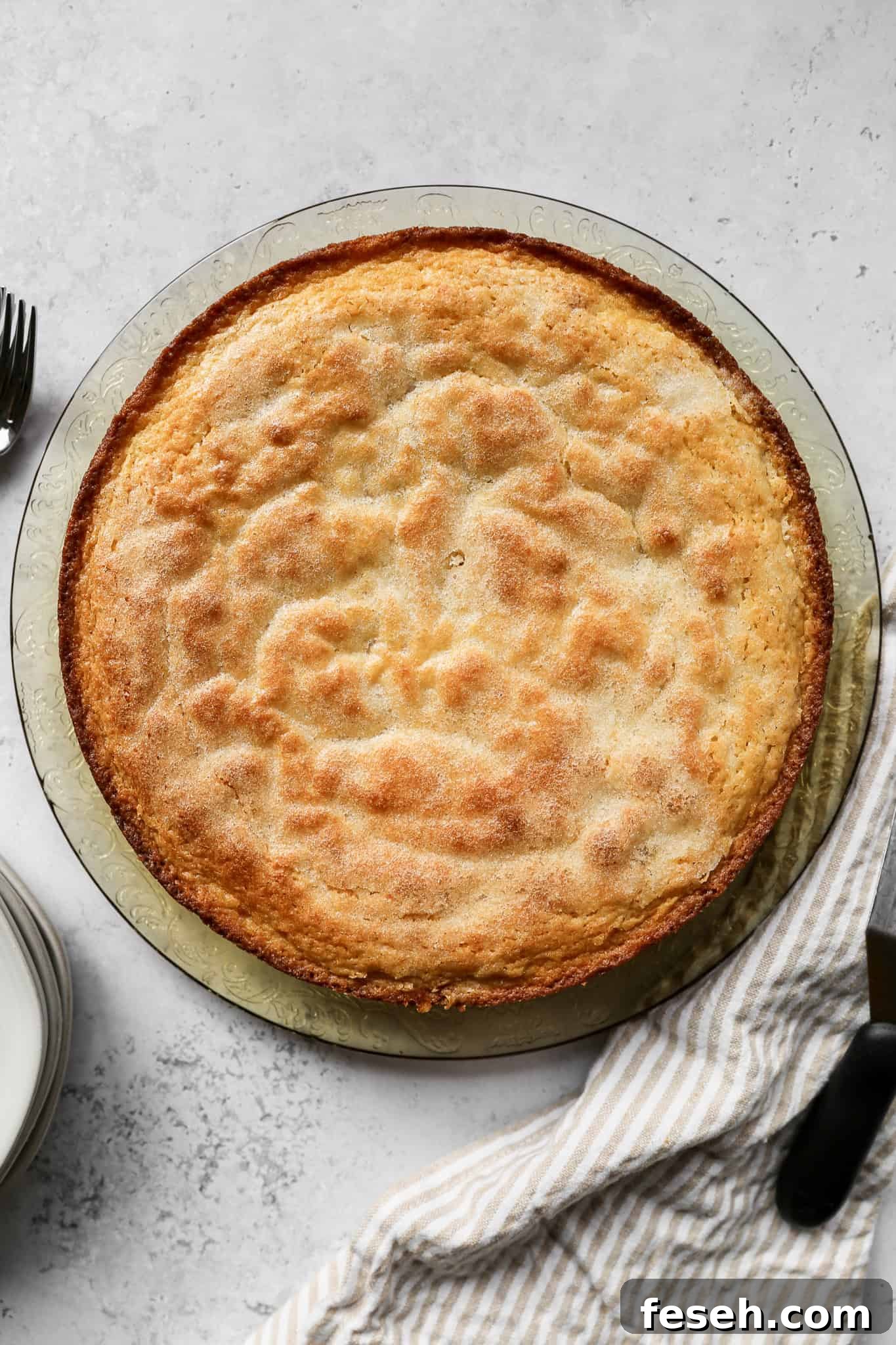 the gluten free lemon olive oil cake on a platter before having powdered sugar sprinkled on top.